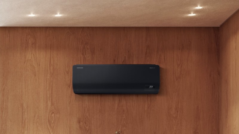 Černá klimatizace Samsung WindFree v moderním interiéru s dřevěnou stěnou
